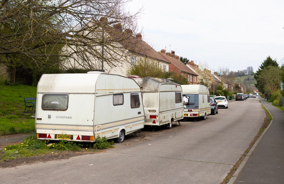 Several caravans parked on a residential street.