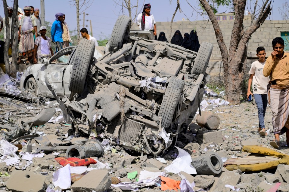 An overturned car amidst rubble and debris following an airstrike in Yemen.