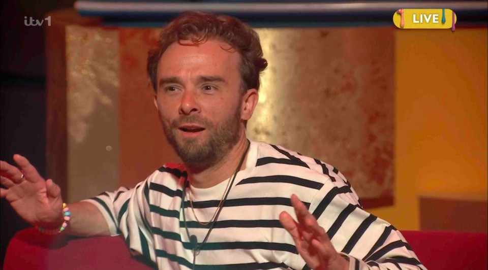 Man in striped shirt speaking on live television.