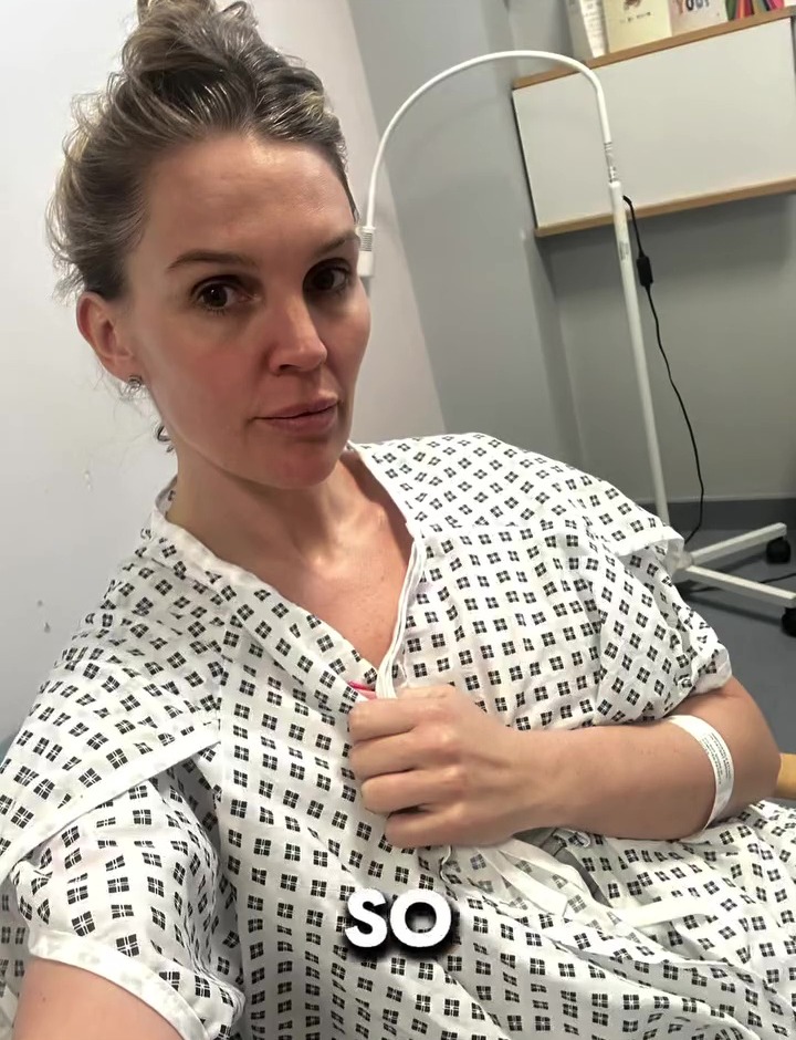 Woman in hospital gown sharing health update.