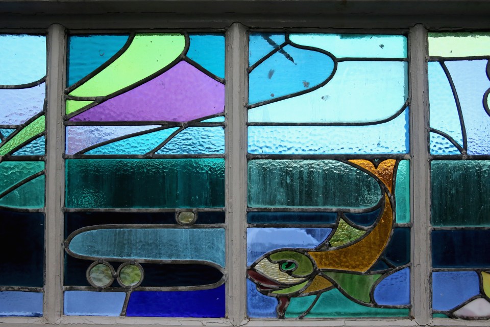 Stained glass window with abstract designs and fish.