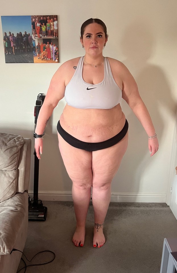 Woman standing in her underwear and sports bra.