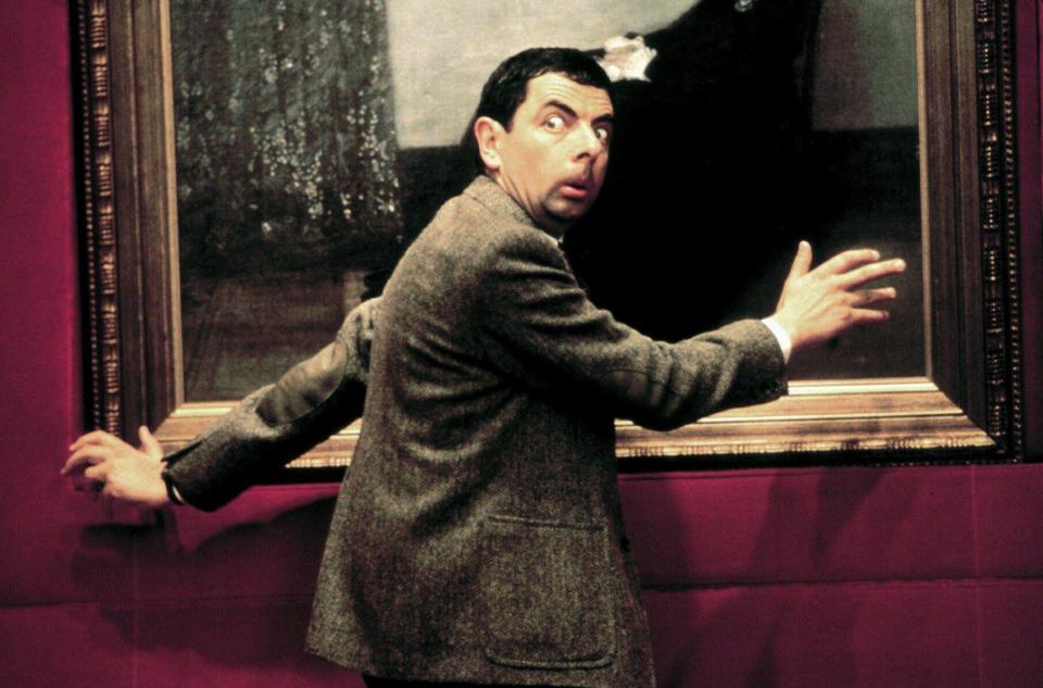 Rowan Atkinson as Mr. Bean examining a painting.