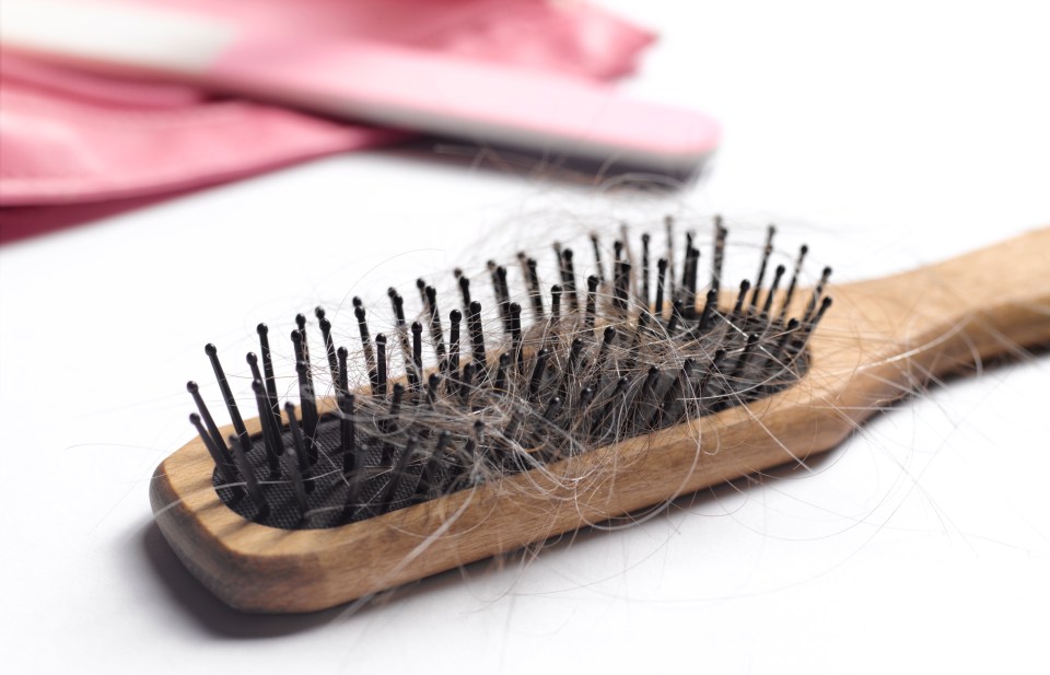 Hairbrush with strands of hair.