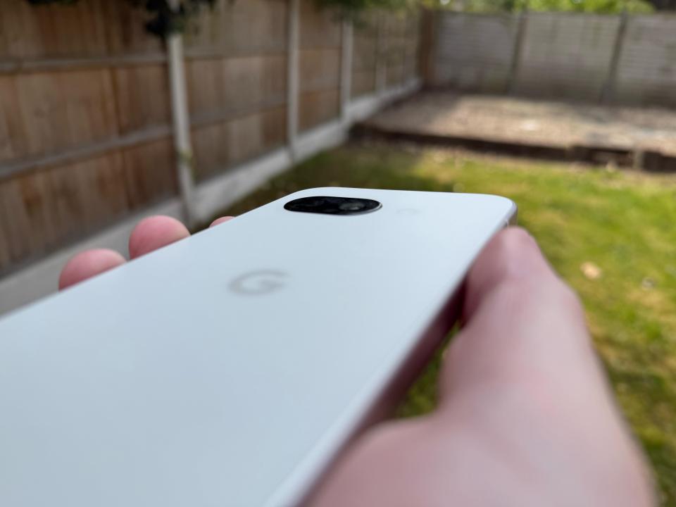 White Google phone held in hand.