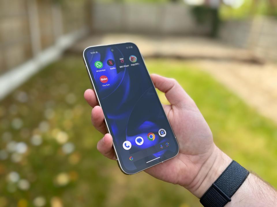 Person holding a smartphone displaying app icons.