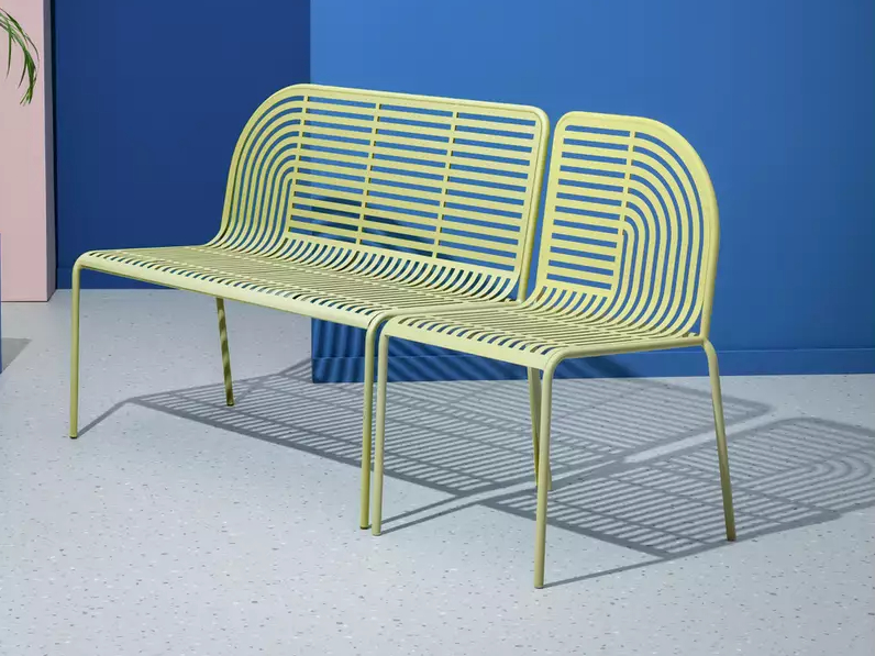 Pale yellow metal bench with slatted back and seat.