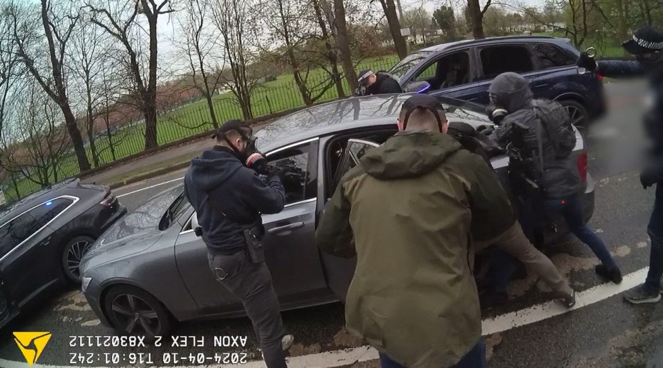 Police officers in gas masks arresting a suspect.