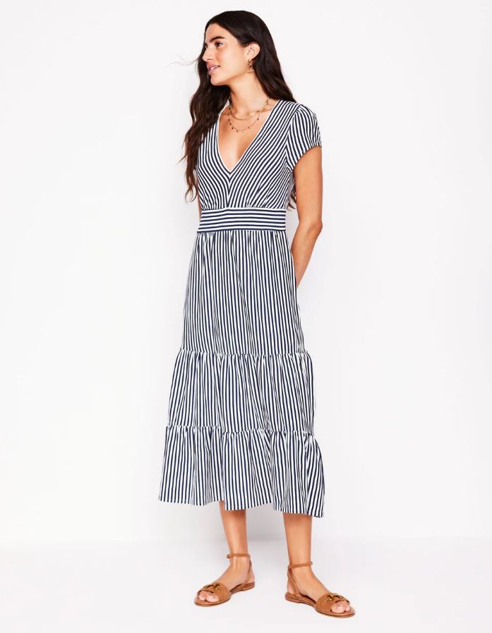Woman in navy and white striped midi dress.