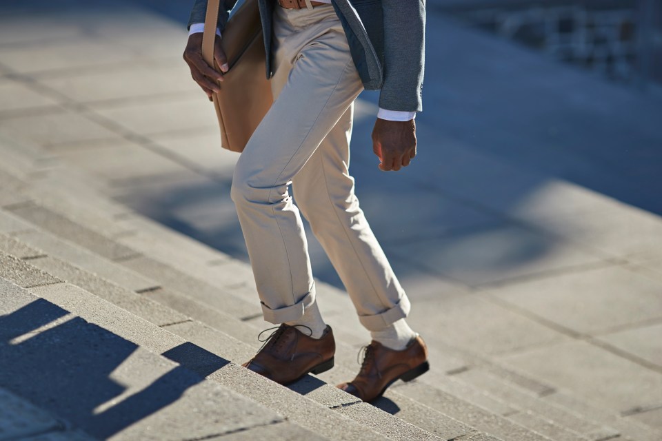 Businessman walking up stairs carrying a briefcase.