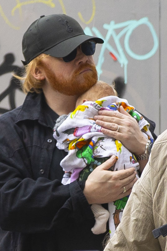 Rupert Grint holding his newborn baby.