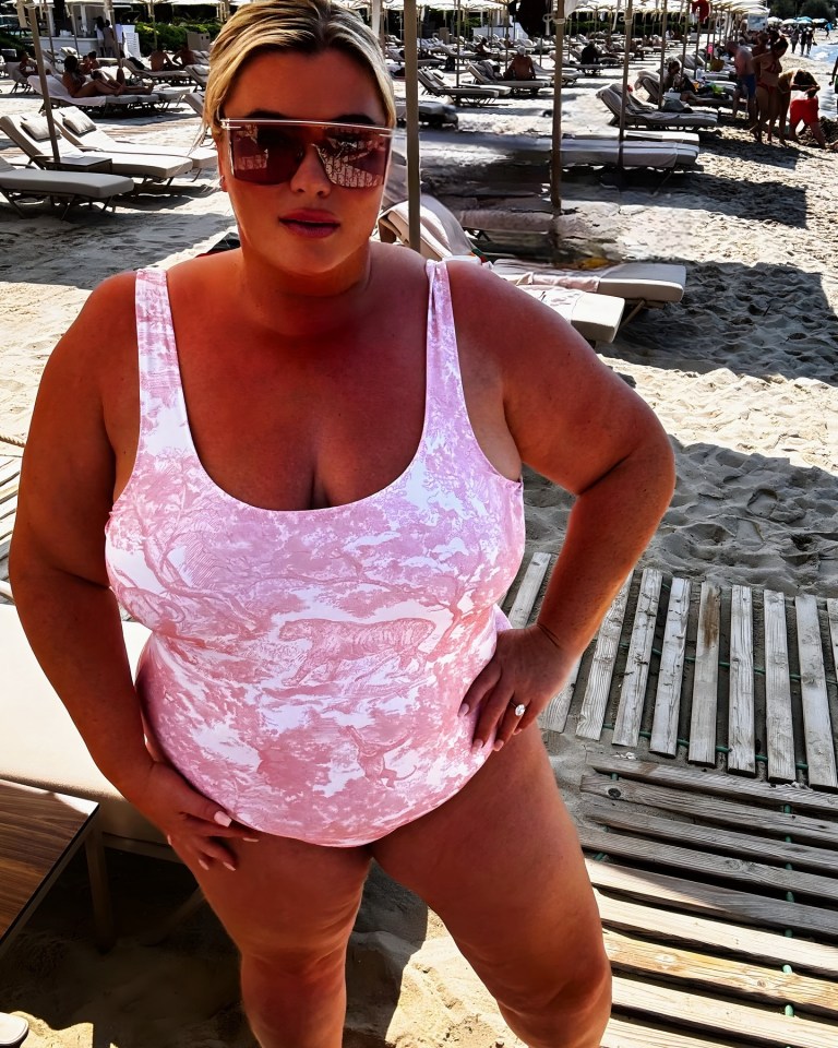 Woman in pink swimsuit on a beach.