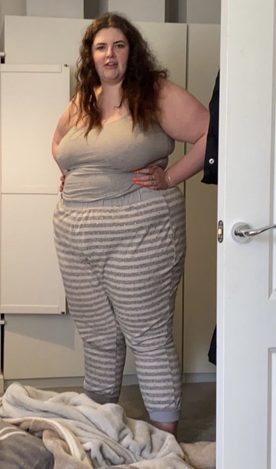 Woman in striped pajama pants and a gray tank top.