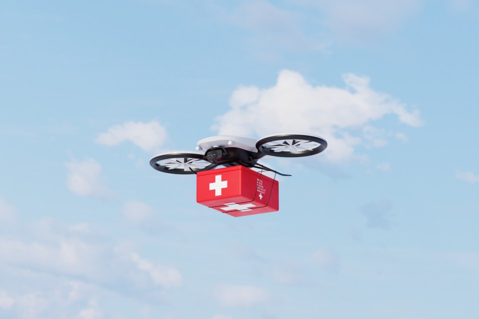 Conceptual image of an autonomous  drone in the sky delivering medical supplies