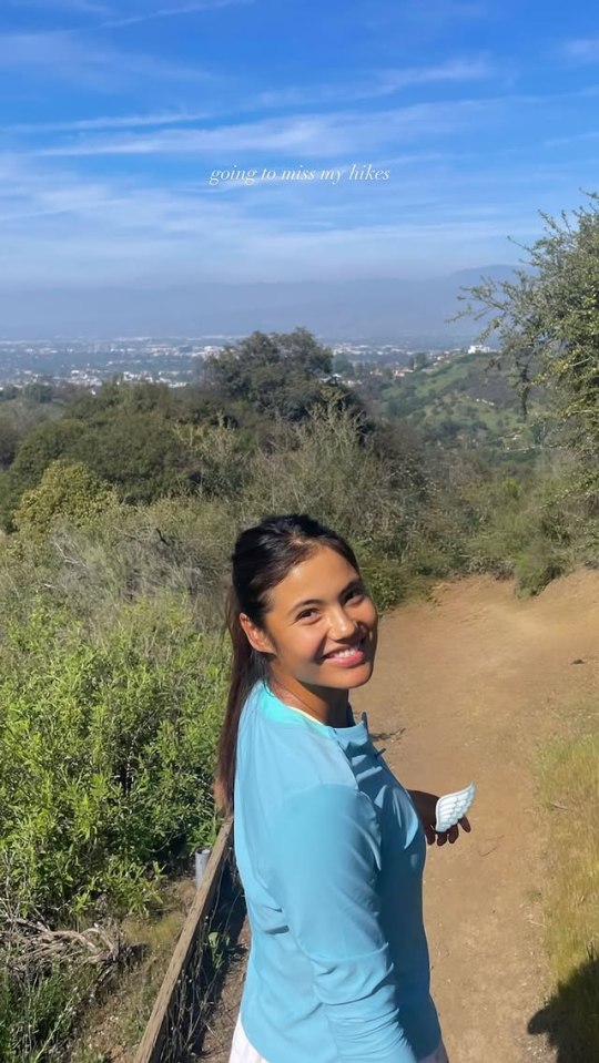 Emma Raducanu on a hike overlooking a city.