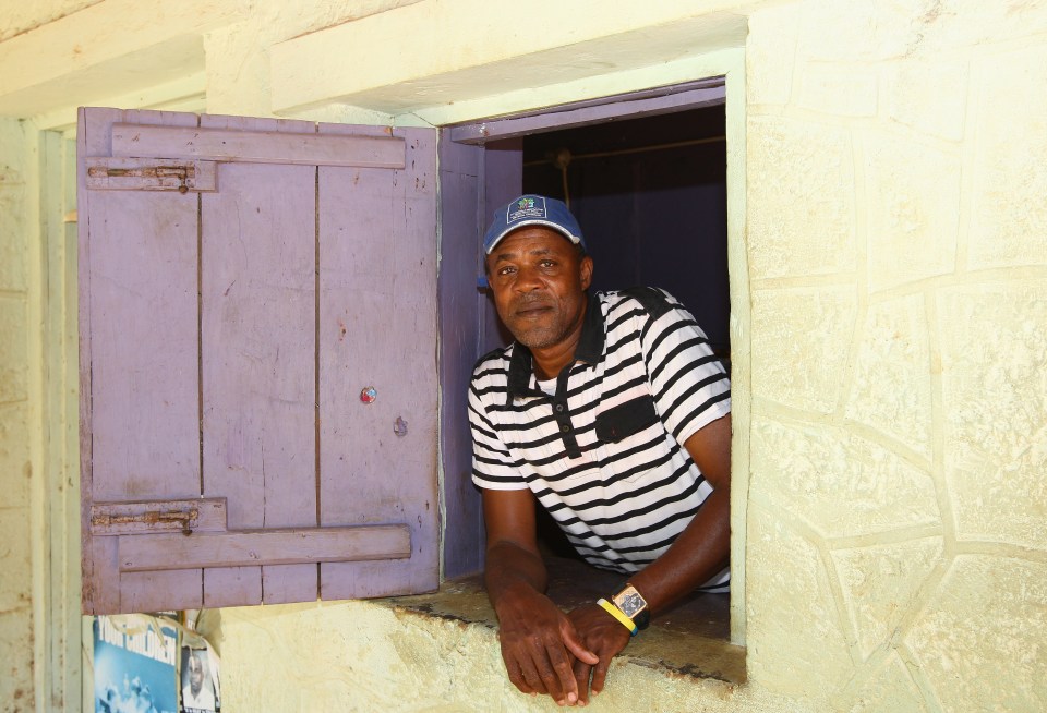 Portrait of Usain Bolt's father looking out the window of his grocery store.