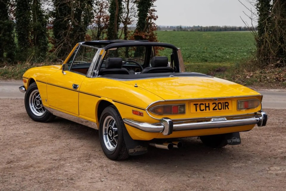 Yellow 1977 Triumph Stag convertible.