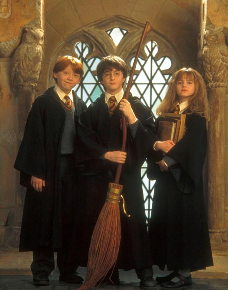 Harry Potter, Ron Weasley, and Hermione Granger in their Hogwarts robes.