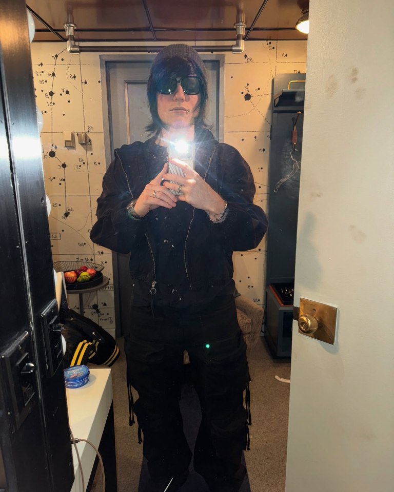 Ed Sheeran in disguise, wearing a black wig and lip piercing.