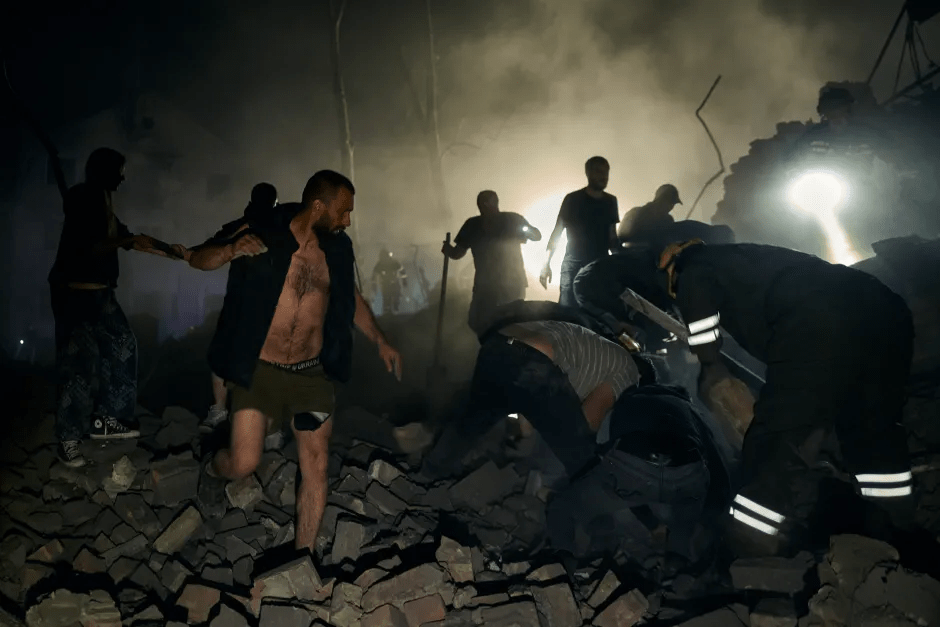 People searching for survivors amidst rubble at night.