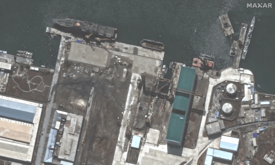 Aerial view of a shipyard with several ships and buildings.