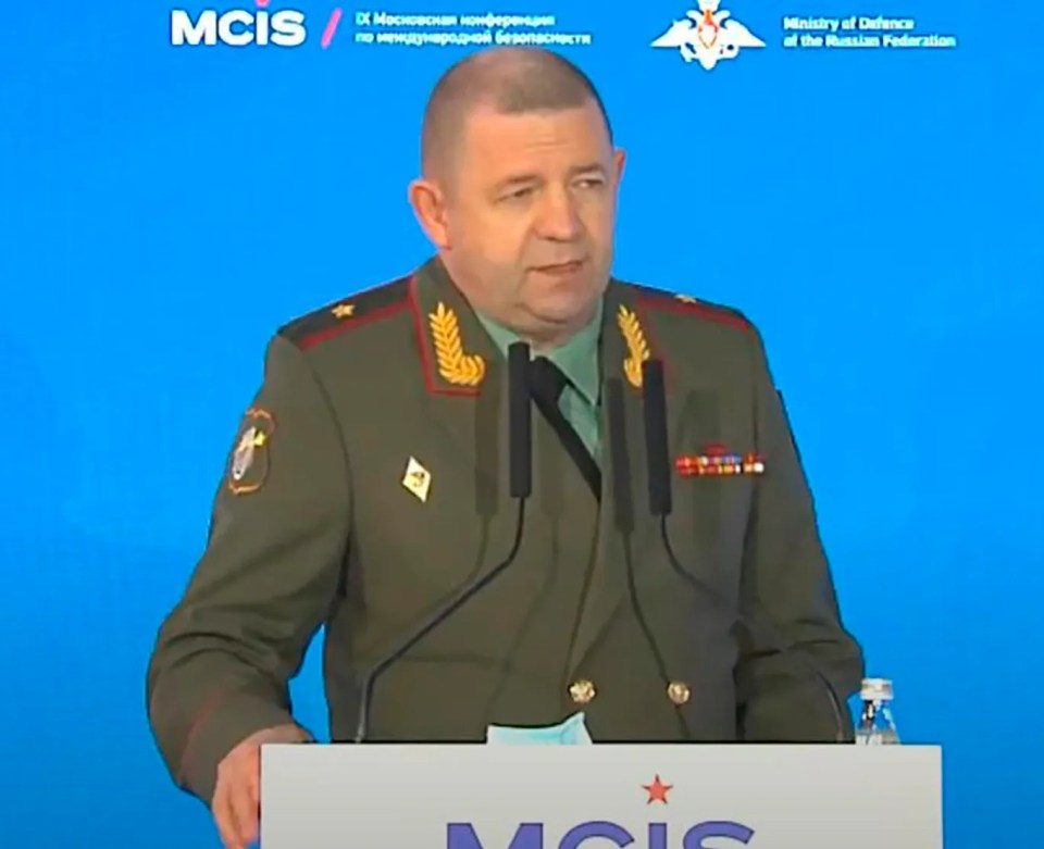 Man in military uniform speaking at a podium.