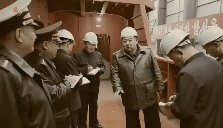 Kim Jong-un and several officials inspecting a shipyard.