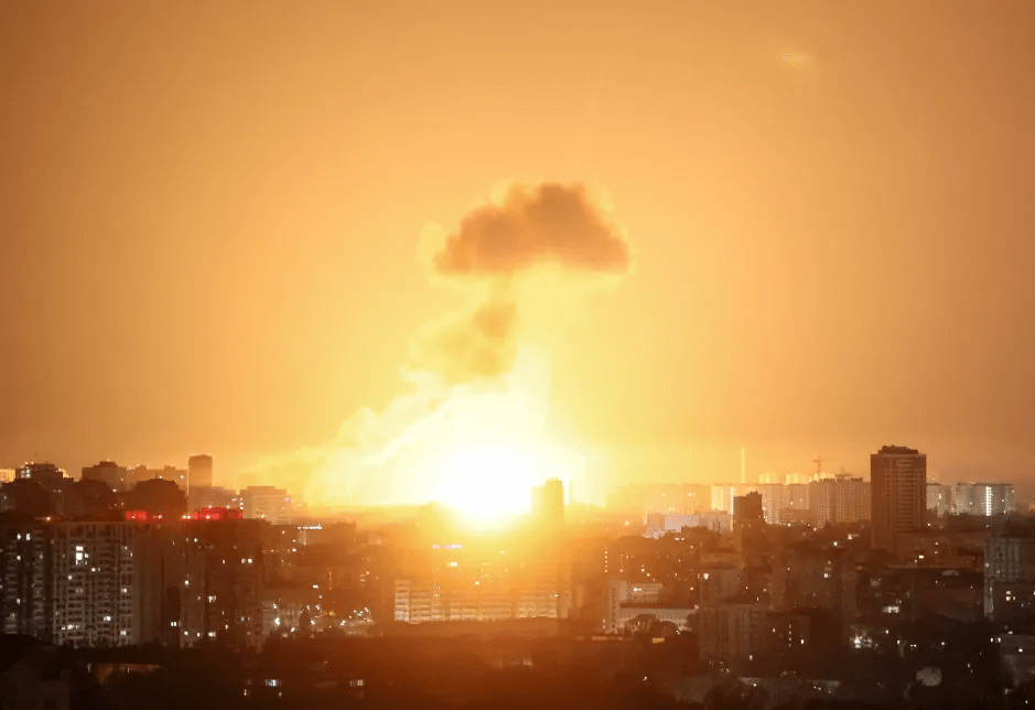 Large explosion over a city at night.