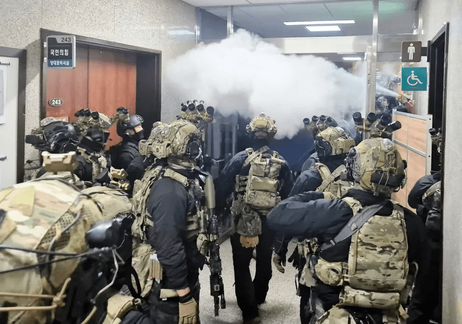 Soldiers in tactical gear entering a building, smoke billowing.