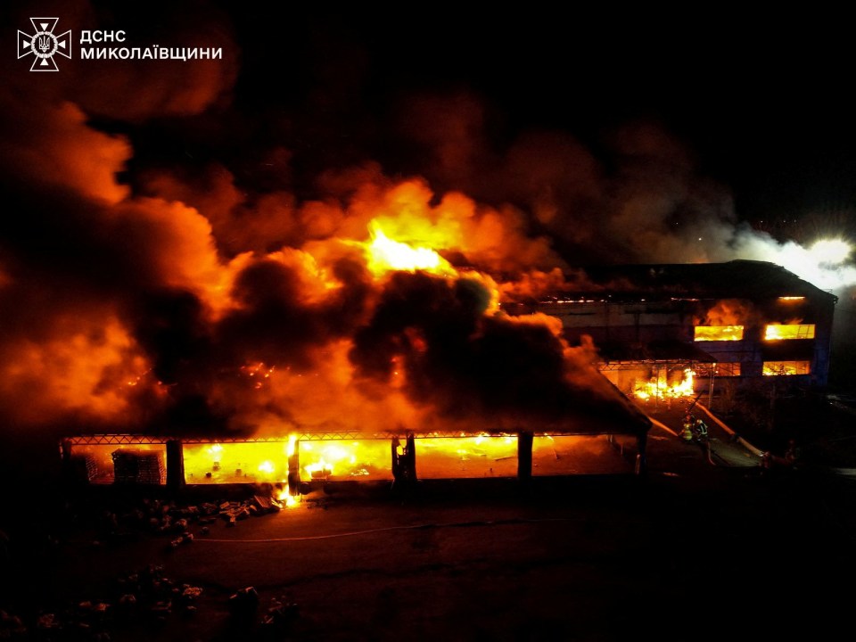 Large building engulfed in flames at night.