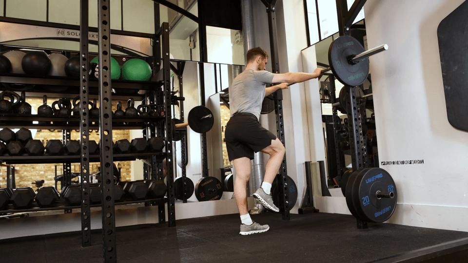 Man performing a leg exercise in a gym.