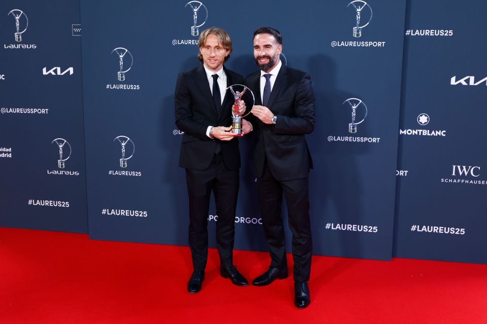 Luka Modric and Daniel Carvajal holding a Real Madrid Team of the Year trophy at the Laureus World Sports Awards.