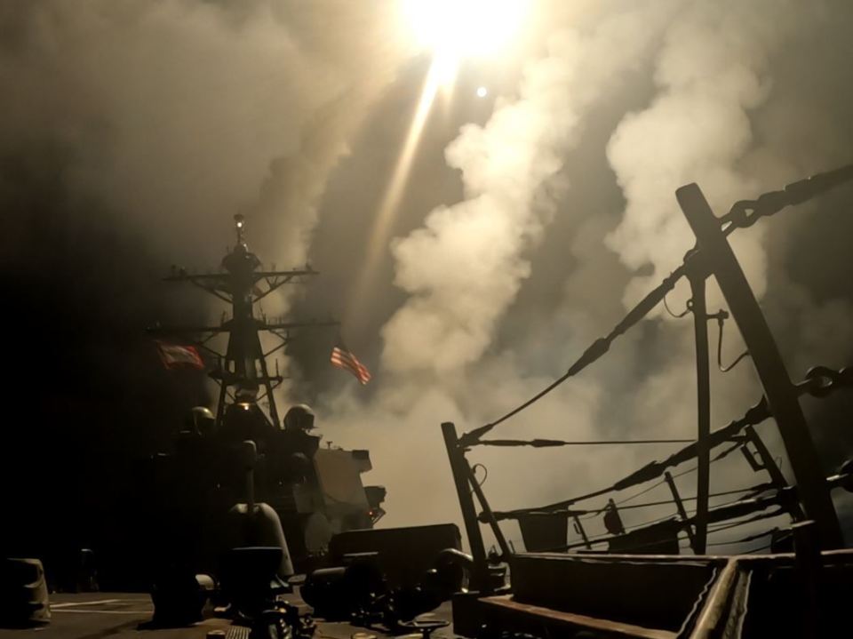 US Navy ship firing missiles in smoky conditions.