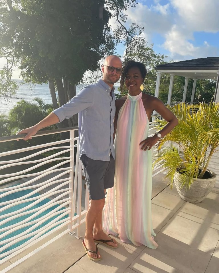 Group photo of two adults and six children on a patio overlooking the ocean.