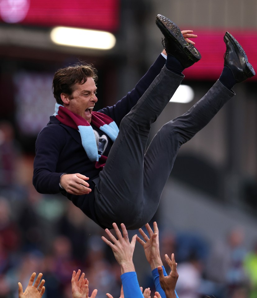 Burnley players lift their manager in celebration.
