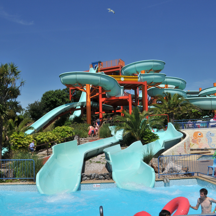 Water park with multiple slides emptying into a pool.