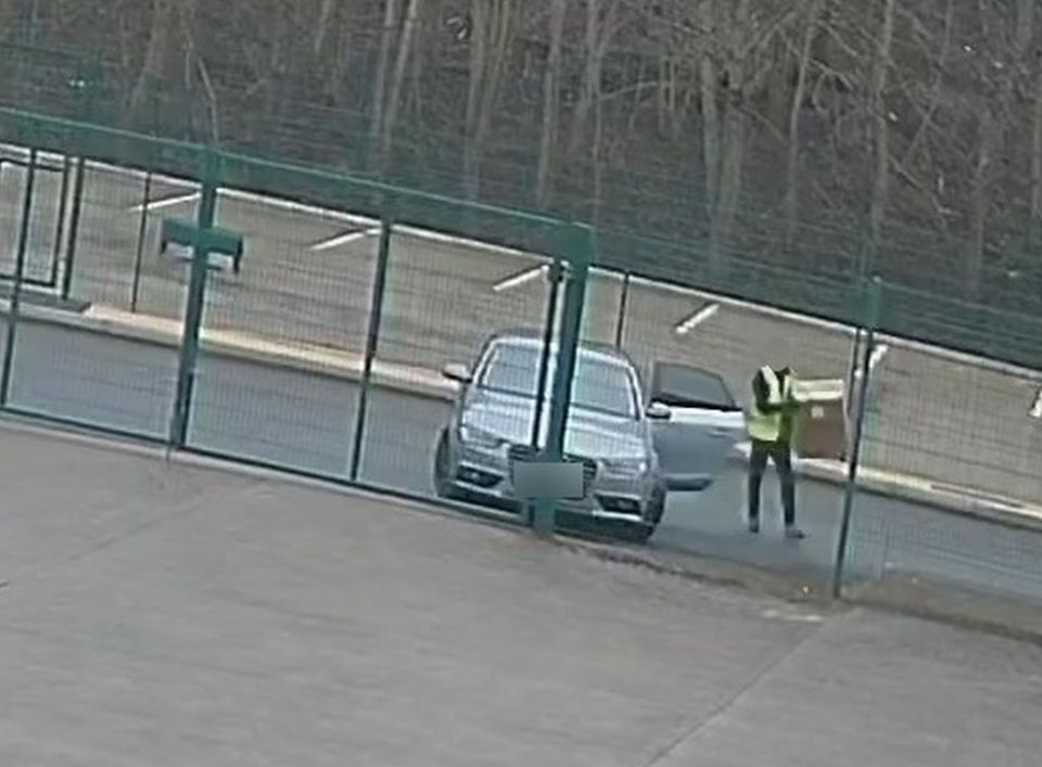 CCTV footage of a delivery driver throwing a parcel over a fence.