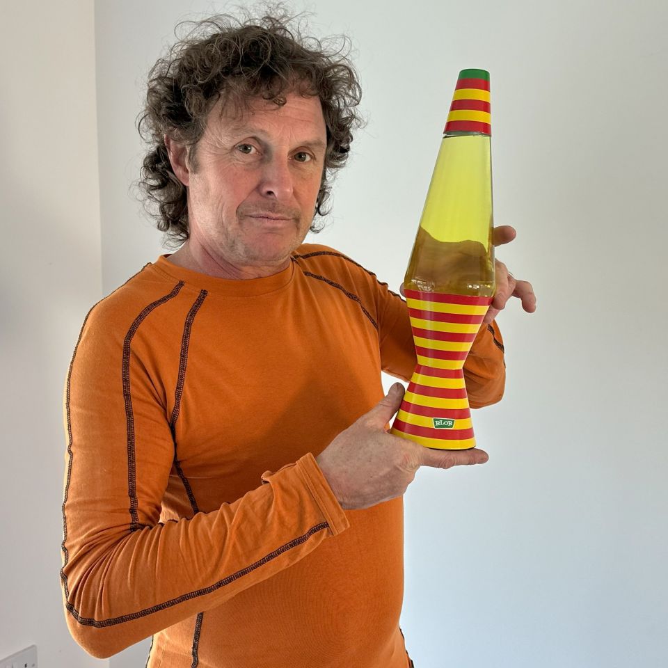 Man holding a broken lava lamp.