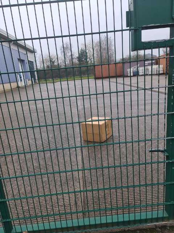 Damaged package beyond a fence.