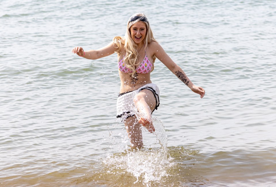 Woman splashing in water at Brighton Beach.