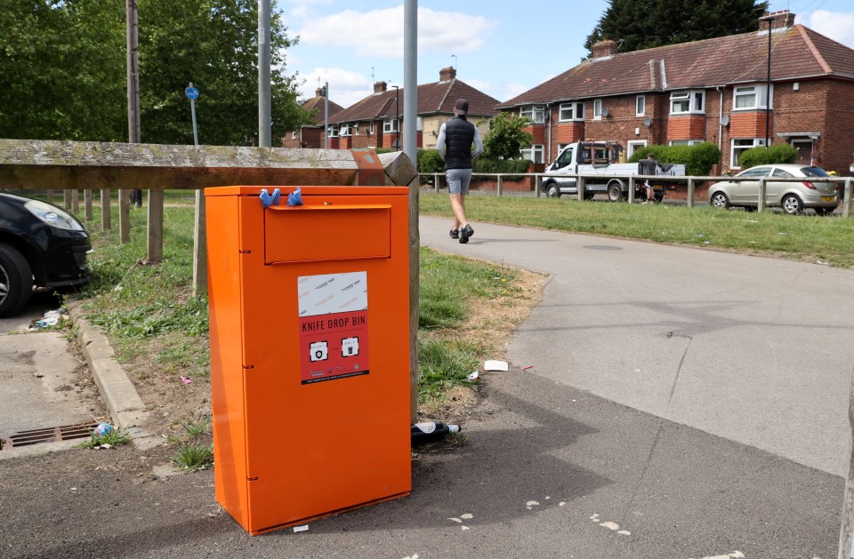 Orange knife drop bin on a residential street.