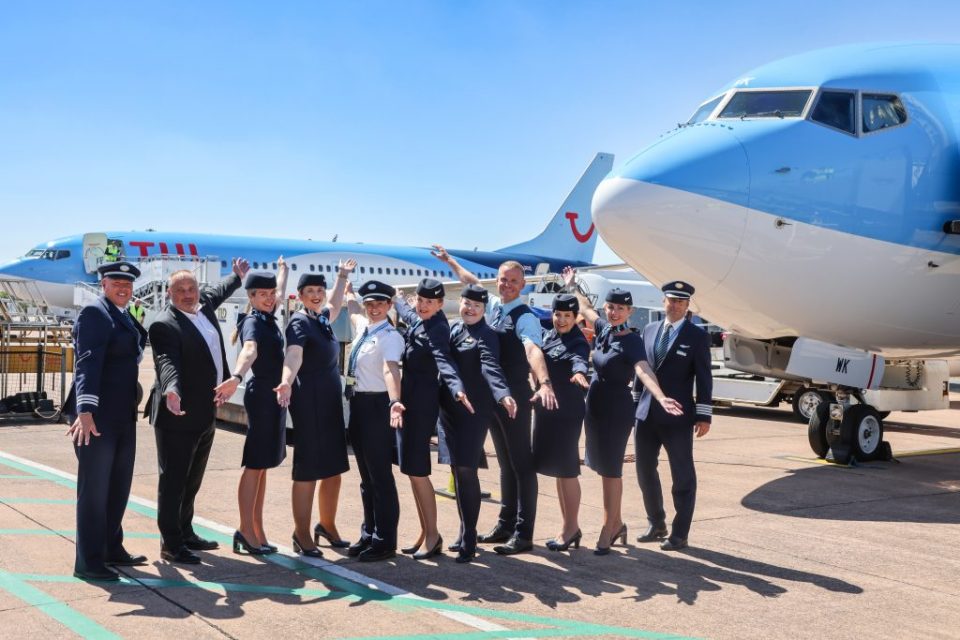 TUI Airways crew and staff posing in front of a plane.