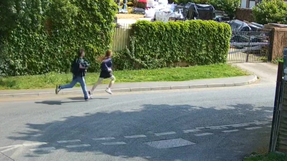 Two people running across a road.