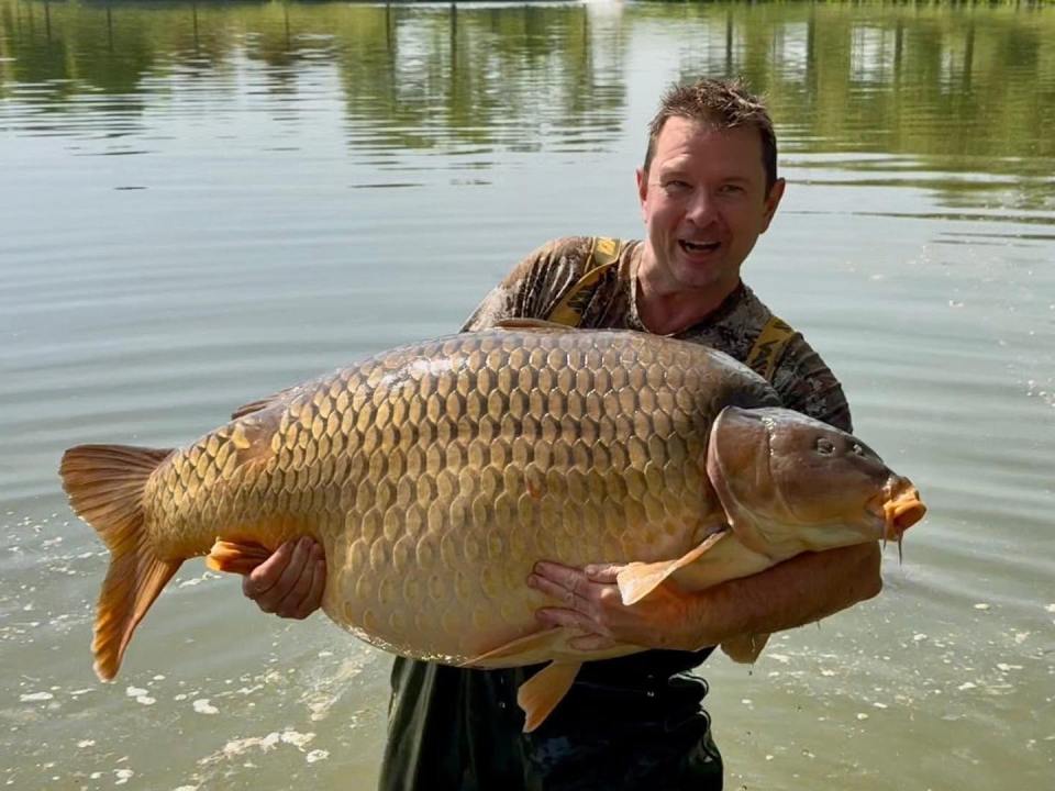 Angler holding a large carp weighing 105.4 lbs.