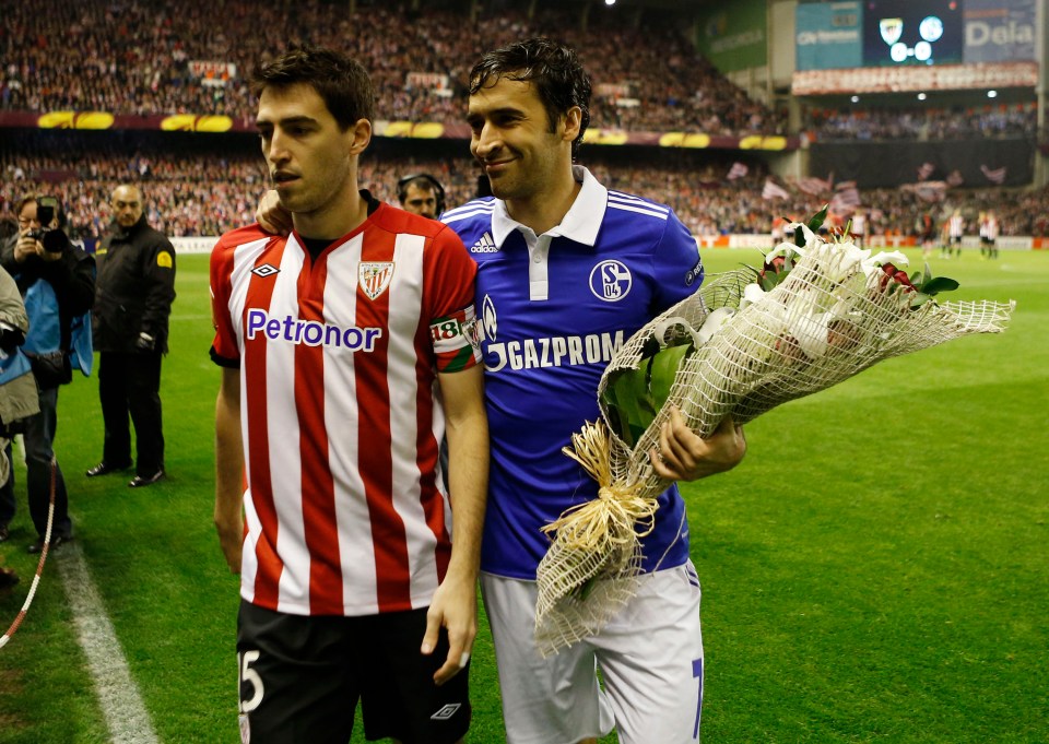 Two soccer players holding a bouquet of flowers.