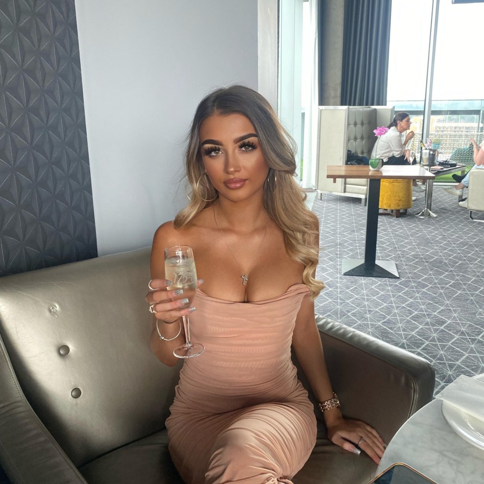 Woman in a pink dress holding a glass of champagne.