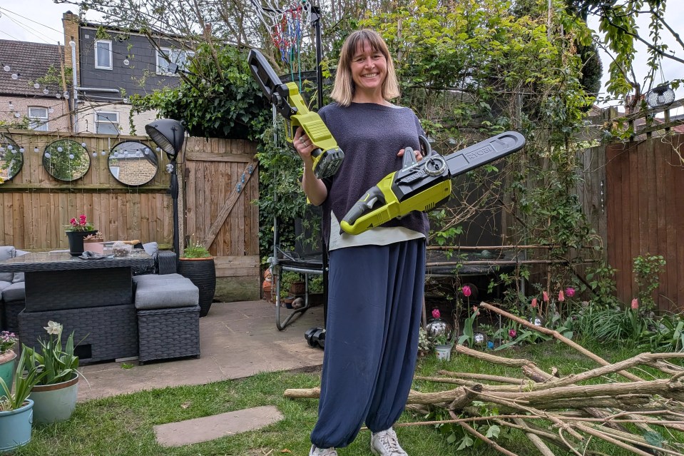 Sun Gardening Editor Veronica Lorraine in a garden holding two of the best chainsaws.