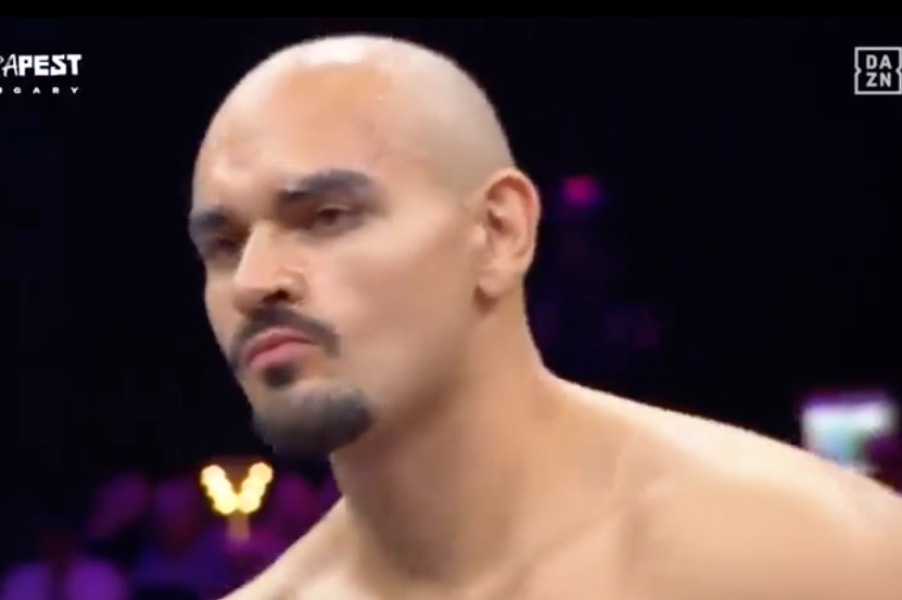 Close-up of a bald, shirtless man with a goatee.
