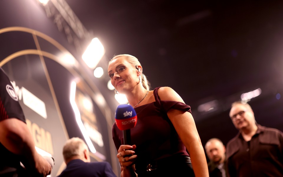 Emma Paton, darts presenter, holding a Sky Sports microphone.