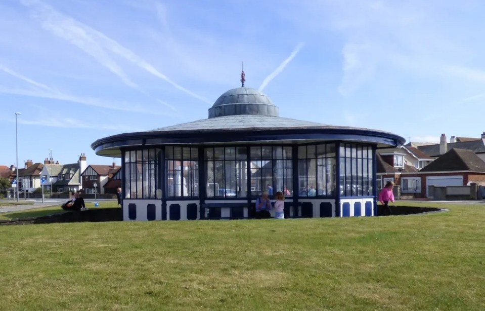 Circular tram shelter with benches and a copper roof.